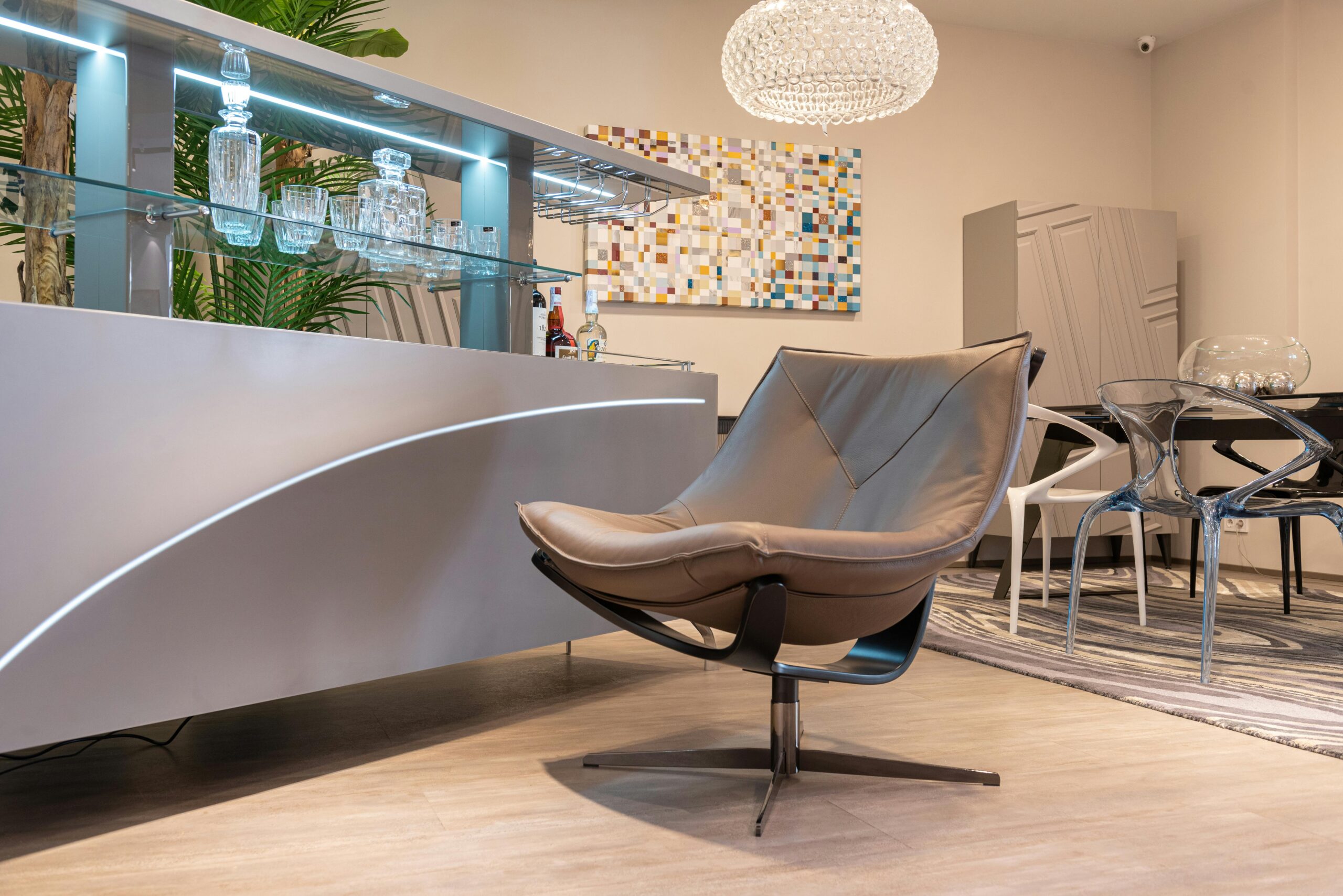 Elegant modern lounge featuring a leather chair and sleek bar setup with glassware.